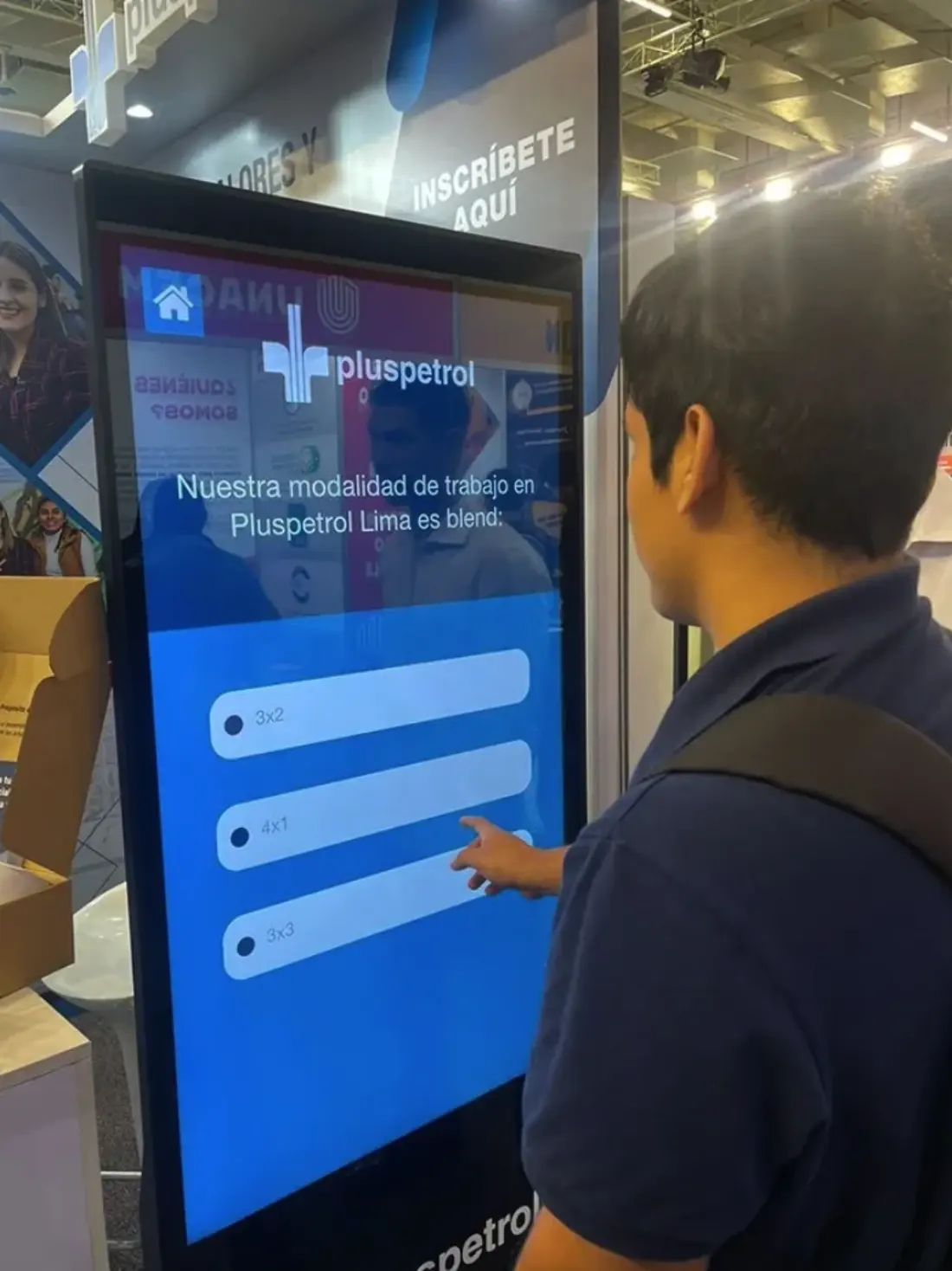 Persona usando una pantalla táctil interactiva de Pluspetrol